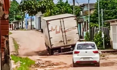 Buraco quase da largura de rua faz caminhão atolar “no seco” em Rio Branco