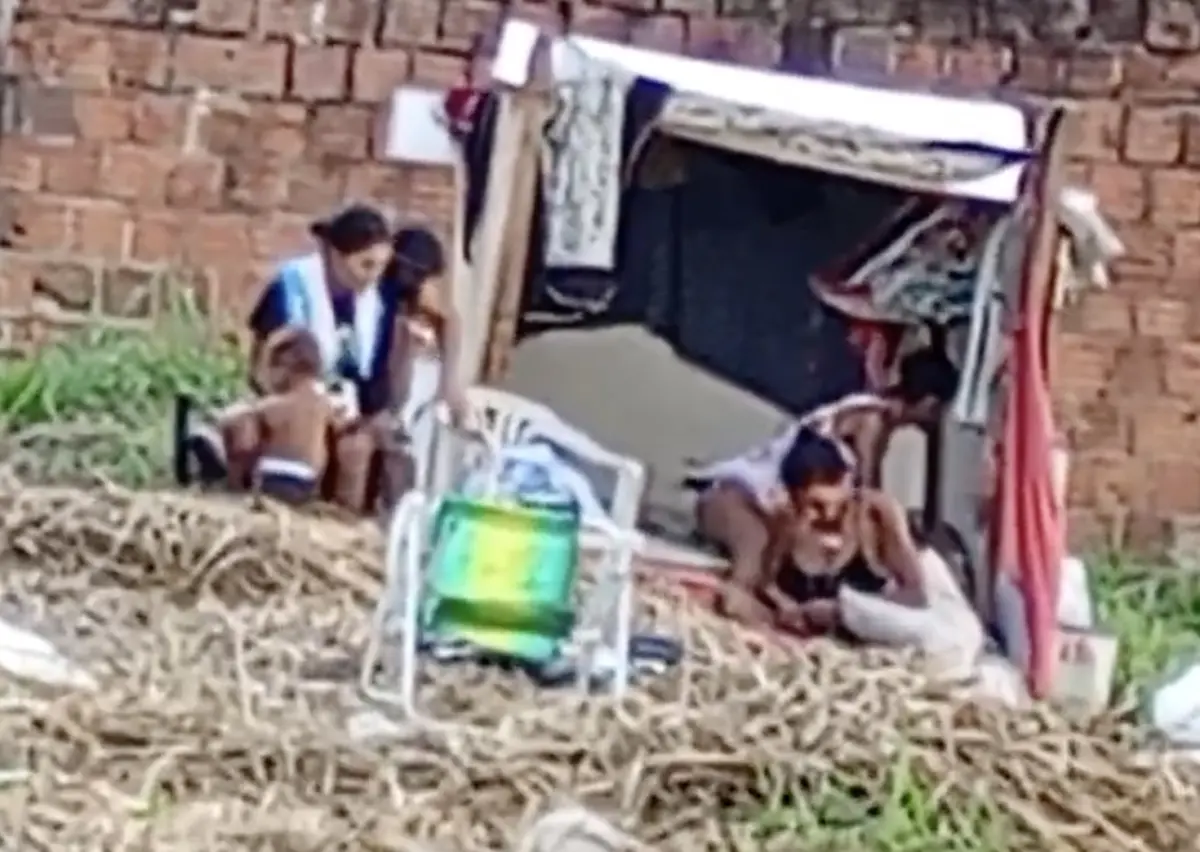 Criança é vista com grupo de adultos em local de uso de drogas