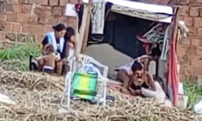 Criança é vista com grupo de adultos em local de uso de drogas
