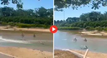 Adolescentes atravessam rio de bicicleta em meio à seca no Jordão