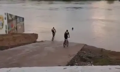 Em plena enchente, jovens pulam no Rio Iaco de bicicleta em Sena Madureira